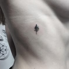 a man with a small tree tattoo on his chest