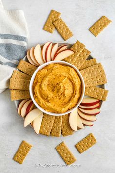 an apple and cheese dip in a bowl surrounded by crackers