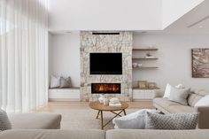 a living room filled with furniture and a flat screen tv mounted on the wall above a fire place