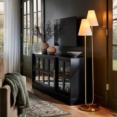 a living room scene with focus on the floor lamp and entertainment center in the background