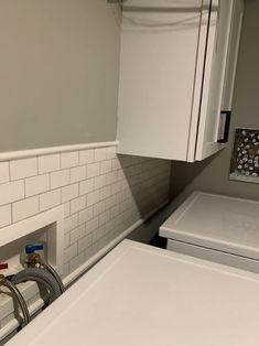 a white washer and dryer sitting next to each other in a room with gray walls