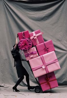 a woman pushing a cart full of pink wrapped presents with the words mood on it