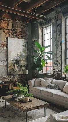 a living room filled with lots of furniture next to windows and potted plants on top of a wooden table