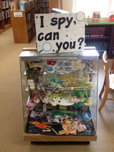 a display case filled with assorted items and a sign that says i spy, can you?