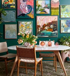 a dining room with green walls and pictures on the wall