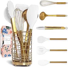 gold and white kitchen utensils in a vase with floral napkins next to it