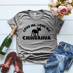 a t - shirt with the words love me, love my chihuahua on it next to some flowers