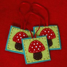 two red and white mushrooms are hanging from a string on a red surface with blue trim