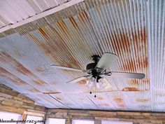 a ceiling fan is hanging from the ceiling in an old room with peeling paint on it