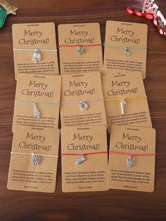 six christmas gift tags sitting on top of a wooden table