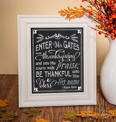 a chalkboard sign with the words enter us gates and thanksgiving written on it next to a white vase filled with autumn leaves