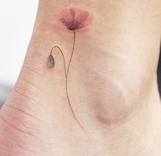 a small flower tattoo on the ankle is shown in this image, it looks to be painted