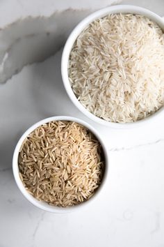 two bowls filled with rice on top of a white counter