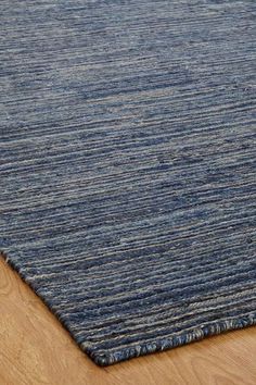 a blue rug on top of a wooden floor next to a wood flooring board