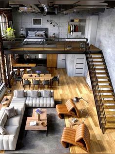 an aerial view of a living room with couches, tables and stairs leading up to the loft