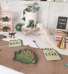 a table topped with paper cut outs and dinosaur decorations