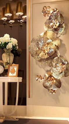 the wall is decorated with gold and white flowers in vases next to a clock