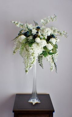 a vase filled with white flowers on top of a wooden table