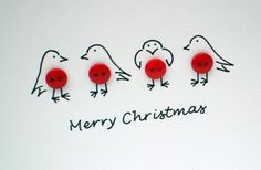 three red buttons with birds on them sitting next to the words merry christmas written in black ink