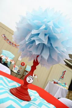 a paper pom - pom tree on top of a table with blue and white decorations