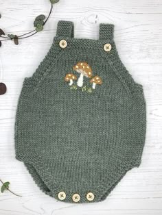 a green knitted overall with mushrooms on it