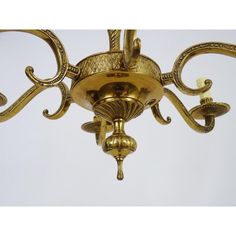 an ornate gold chandelier hanging from the ceiling with two lights on each side