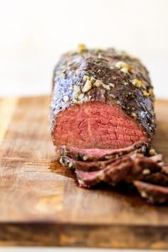 a large piece of meat sitting on top of a wooden cutting board