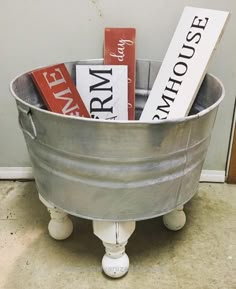 a metal bucket filled with books on top of a floor