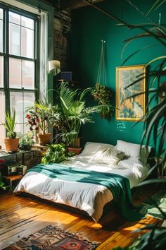 a bedroom with green walls and lots of plants in the window sill, along with a bed