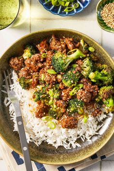 a plate with rice, broccoli and ground beef on it next to other dishes