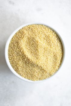 a white bowl filled with yellow sesame seeds