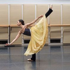 a woman in a yellow dress is doing a dance move on the floor with her legs spread out