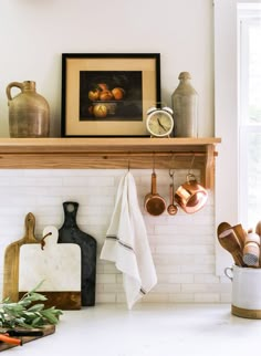 a kitchen counter with pots, pans and utensils hanging on the wall