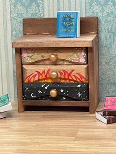 a wooden night stand with two drawers and a book sitting on it's side