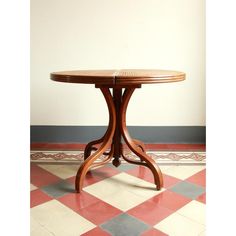 a wooden table sitting on top of a red and white checkerboard tile floor