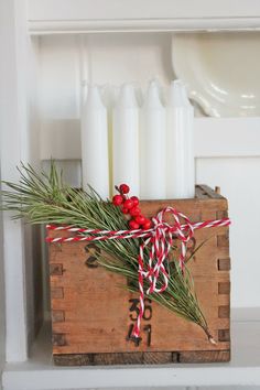 a wooden crate filled with candles on top of a shelf