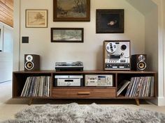 an entertainment center with various audio equipment and pictures on the wall