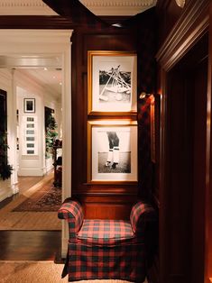 a red and black checkered chair sitting in front of a wooden framed photo on the wall