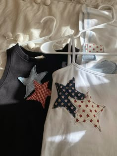 two shirts with stars on them hanging from clothes pins