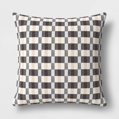 a black and white checkered pillow on a gray wall