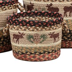 three woven baskets with moose and pineconi designs on them, one is multicolored