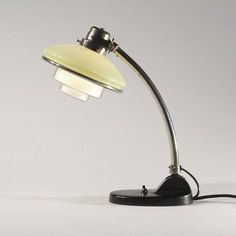 a lamp that is sitting on top of a table next to a white wall and floor