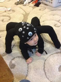 a small child wearing a black spider costume