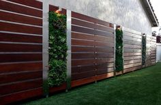 a fence with plants growing on it and some lights in the top right hand corner