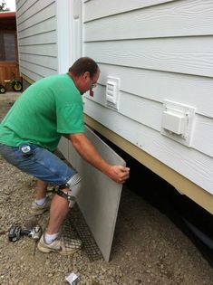 a man in green shirt working on siding