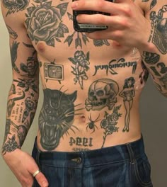 a man with tattoos on his chest holding a cell phone