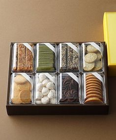 a box filled with assorted cookies and crackers on top of a table next to a yellow box