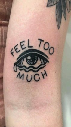 a woman's arm with a tattoo saying, feel too much and an eye on it