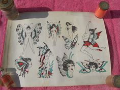 an old sheet of paper with tattoos on it next to two bottles and some scissors