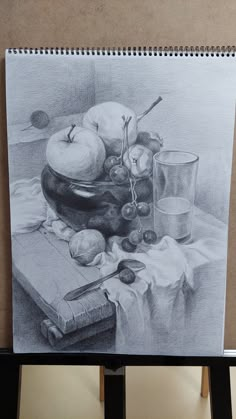 a drawing of apples and other fruit on a table next to a book with glasses